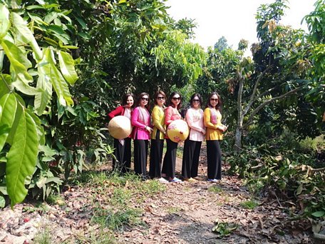 Khách du lịch nội địa thích thú chụp hình trong vườn cây trái ở cồn Công.