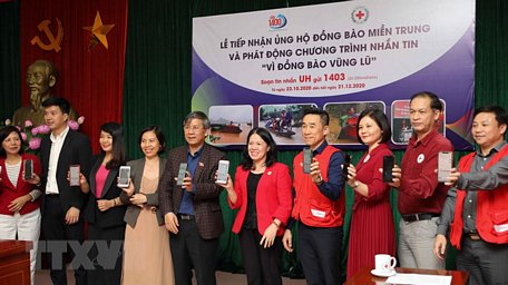 Lãnh đạo Hội Chữ thập đỏ Việt Nam và các đại biểu nhắn tin ủng hộ Vì đồng bào vùng lũ. (Ảnh: Thanh Tùng/TTXVN)