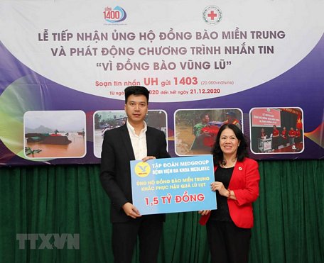 Chủ tịch Hội Chữ thập đỏ Việt Nam Nguyễn Thị Xuân Thu tiếp nhận ủng hộ đồng bào miền Trung từ các cơ quan, tổ chức và doanh nghiệp. (Ảnh: Thanh Tùng/TTXVN)