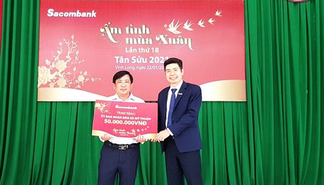 Ông Cao Hồng Sơn- Giám đốc Sacombank chi nhánh Vĩnh Long (bên trái) trao biểu trưng cho ông Nguyễn Thành Thái- Phó Chủ tịch UBND xã Mỹ Thuận (huyện Bình Tân).