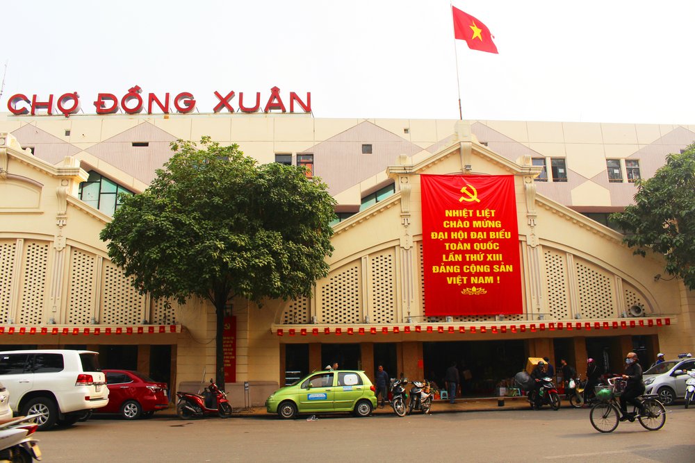 Chợ Đồng Xuân- một trong những chợ lớn nhất tại Hà Nội rực rỡ với cờ nước, khẩu hiệu.