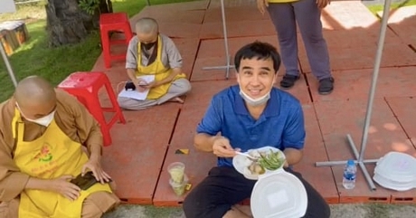 MC Quyền Linh mặc trang phục giản dị, đi dép tổ ong khi trực tiếp trao quà cho người dân có hoàn cảnh khó khăn. (Ảnh: FBNV)