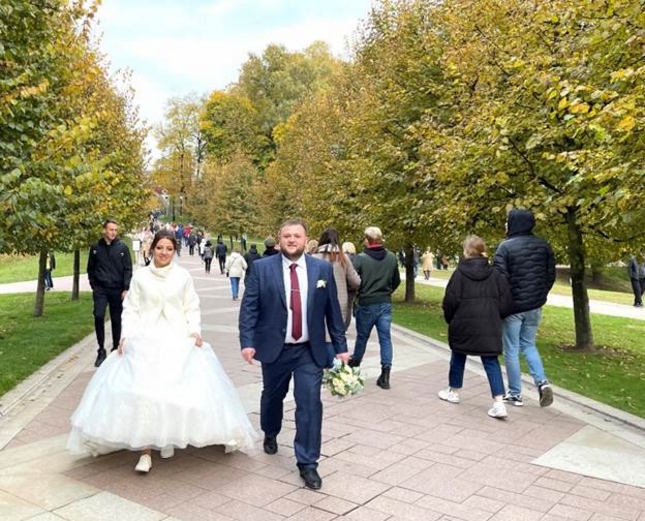 Đôi vợ chồng mới cưới cùng nhau đi dọc công viên