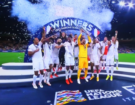 Đúng 4 giờ sáng 11/10, thủ môn đội trưởng Pháp Hugo Lloris nâng cao chiếc cúp vô địch đầu tiên UEFA Nations League. Ảnh chụp qua màn hình ti vi 