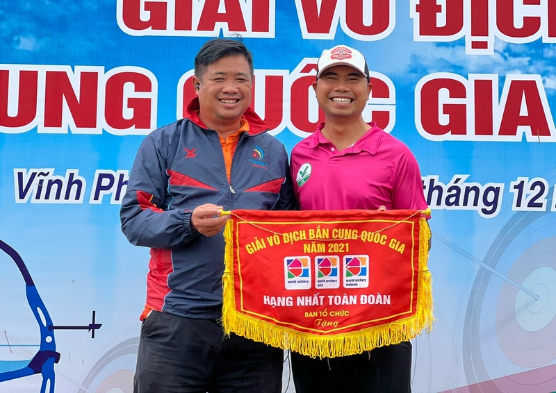 HLV Hồ Thanh Sang và HLV Đỗ Văn Duy phấn khởi nhận cờ nhất toàn đoàn tại Giải Vô địch quốc gia 2021.