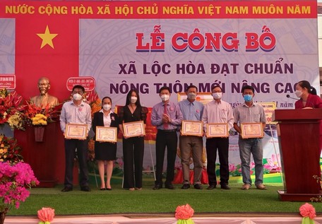 Ông Nguyễn Chí Cường- Phó Chủ tịch UBND huyện Long Hồ trao giấy khen của UBND huyện cho các đơn vị, doanh nghiệp đóng góp tích cực cho chương trình xây dựng NTM nâng cao.