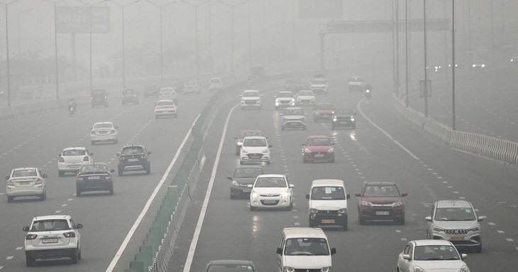 Xe cộ di chuyển trong màn sương và bụi ô nhiễm ở Delhi, Ấn Độ - Ảnh: AFP