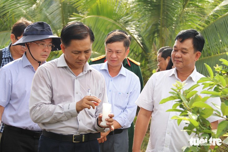 Ông Trần Văn Lâu - chủ tịch UBND tỉnh Sóc Trăng (bìa trái, hàng đầu) xem người dân trồng cây thích ứng với hạn mặn - Ảnh: KHẮC TÂM