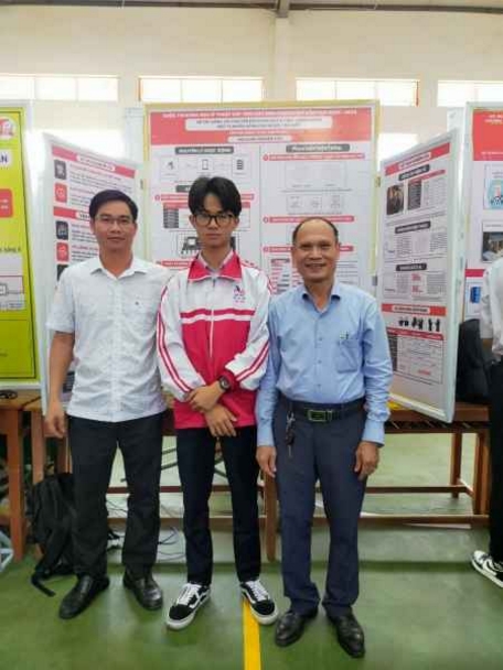 Thầy Hồ Văn Lâm (bìa trái), giáo viên hướng dẫn Long trong dự án găng tay chuyển ngữ, cùng thầy hiệu trưởng Trường THPT Chuyên Lê Quý Đôn chụp ảnh kỷ niệm trong Cuộc thi Khoa học, kỹ thuật cấp tỉnh.