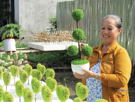 Bà Oanh bên những mẫu sản phẩm “cỏ may mắn” của mình.