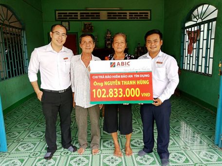 Ông Võ Văn Hoàng- đại diện ABIC (phải) và ông Lê Hoàng Phước- đại diện Agribank KCN Hòa Phú (trái) trao biểu trưng chi trả bảo hiểm cho khách hàng.