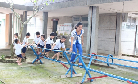 Cô và trẻ cùng đi cầu tre ở Trường Mầm non thị trấn Vũng Liêm.