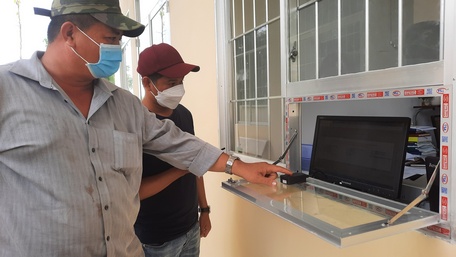 Người dân bấm chọn biển số ô tô tại Công an huyện Vũng Liêm.